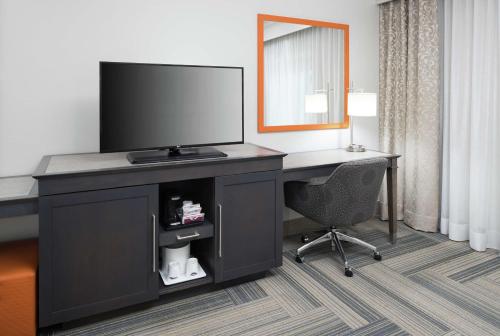 a desk with a tv and a chair in a hotel room at Hampton Inn & Suites by Hilton Atlanta Perimeter Dunwoody in Atlanta