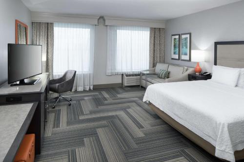 a hotel room with a bed and a flat screen tv at Hampton Inn & Suites by Hilton Atlanta Perimeter Dunwoody in Atlanta
