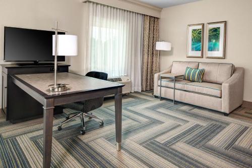 a hotel room with a desk and a couch at Hampton Inn & Suites by Hilton Atlanta Perimeter Dunwoody in Atlanta