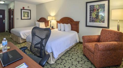a hotel room with two beds and a desk and a chair at Hilton Garden Inn Auburn/Opelika in Auburn