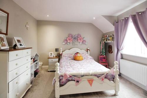 um quarto para crianças com uma cama branca e uma janela em Tirmacspird Road 