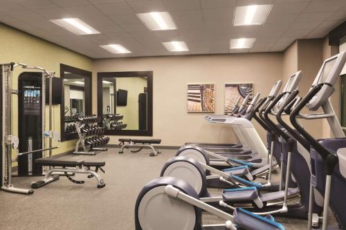 a gym with rows of tread machines and mirrors at Home2 Suites By Hilton Birmingham Downtown in Birmingham