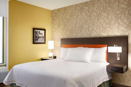 a bedroom with a large white bed with two lamps at Home2 Suites By Hilton Birmingham Downtown in Birmingham