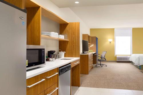 a room with a kitchen with a television and a bed at Home2 Suites By Hilton Birmingham Downtown in Birmingham