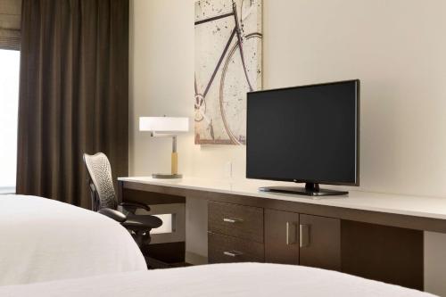 a hotel room with a desk with a television on it at Hilton Garden Inn Downtown Birmingham in Birmingham