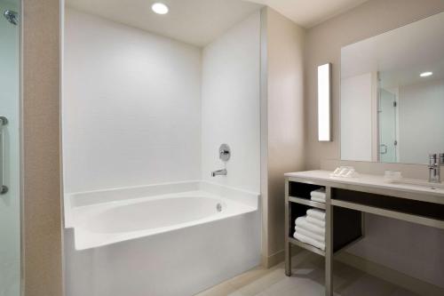 a white bathroom with a tub and a sink at Hilton Garden Inn Downtown Birmingham in Birmingham