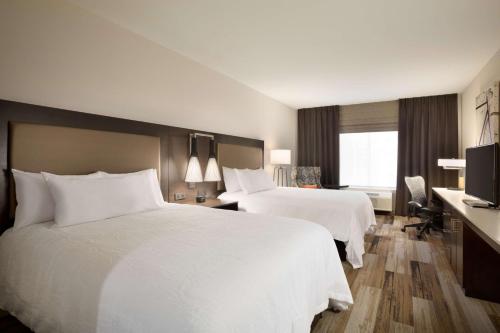 a hotel room with two beds and a desk at Hilton Garden Inn Downtown Birmingham in Birmingham