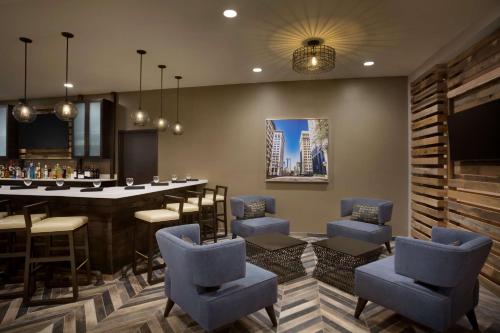 a bar with chairs and a table in a room at Hilton Garden Inn Downtown Birmingham in Birmingham