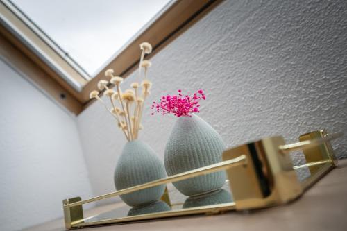 two vases on a shelf with flowers in them at Engel 16 in Gutach