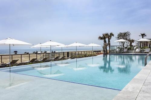 a swimming pool with chairs and umbrellas next to the beach at Marriott Virginia Beach Oceanfront Resort in Virginia Beach