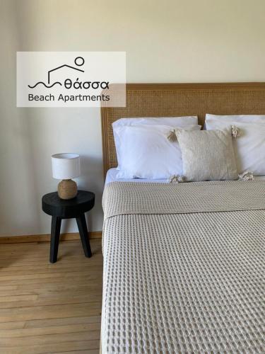 a bedroom with a bed and a table and a sign at Thassa Beach Apartment No1 (with mountain view) in Leonidion