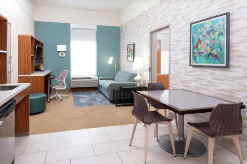 a kitchen and living room with a table and chairs at Home2 Suites by Hilton Fayetteville Fort Bragg in Fayetteville