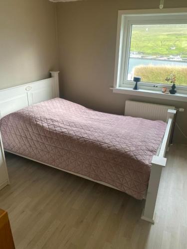Ce lit se trouve dans un dortoir doté d'une fenêtre. dans l'établissement Cosy house in the old village, à Miðvágur