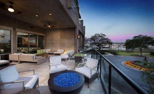 einen Balkon mit Stühlen und einem Tisch auf einem Gebäude in der Unterkunft Hilton Garden Inn Charleston Waterfront/Downtown in Charleston