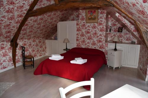 a bedroom with a red bed in a attic at La Halte du Clos in Cour-Cheverny