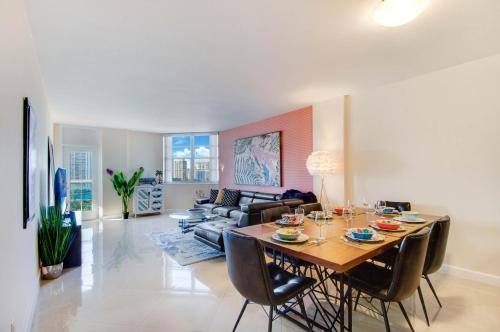 a living room with a table and a couch at Family Beach Home w Ocean & Bay Views - Upgraded Corner Unit in Miami Beach