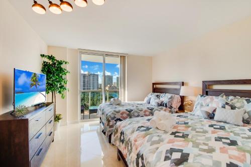 a bedroom with two beds and a flat screen tv at Family Beach Home w Ocean & Bay Views - Upgraded Corner Unit in Miami Beach