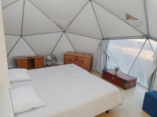 sypialnia z białym łóżkiem w namiocie w obiekcie Forest Domes w mieście Setúbal