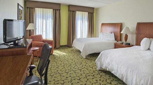 a hotel room with two beds and a flat screen tv at Hilton Garden Inn Huntsville/Space Center in Huntsville