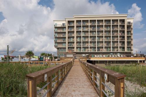 a hotel on the beach with a bridge and a building at Hampton Inn & Suites by Hilton Carolina Beach Oceanfront in Carolina Beach