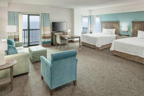 a hotel room with two beds and a television at Hampton Inn & Suites by Hilton Carolina Beach Oceanfront in Carolina Beach