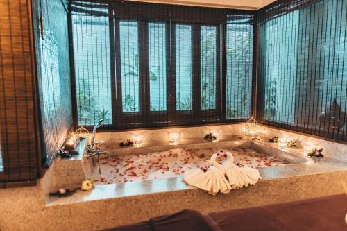 茶云莱海滩Sheraton Samui Resort的浴缸里拿着一束鲜花的新娘