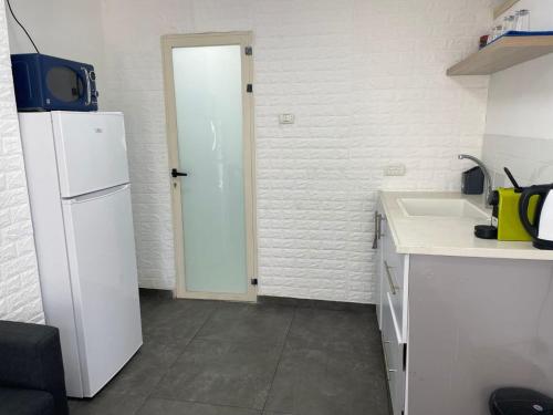 a kitchen with a white refrigerator and a sink at פינה בעמק in Bet Sheʼan