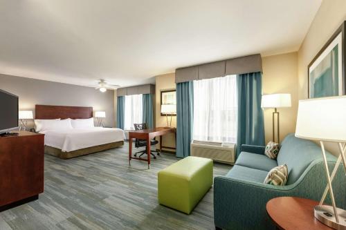 a hotel room with a bed and a couch at Homewood Suites by Hilton Macon-North in Macon