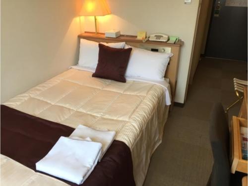 a hotel room with a large bed with two pillows at Sunwest Hotel Sasebo - Vacation STAY 22133v in Sasebo