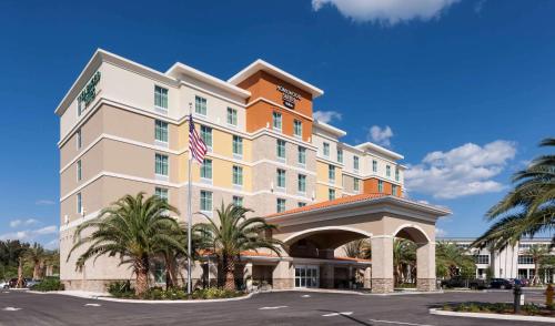 a rendering of a hotel with palm trees in front of it at Homewood Suites by Hilton Cape Canaveral-Cocoa Beach in Cape Canaveral