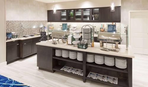 a kitchen with a counter with plates on it at Homewood Suites by Hilton Cape Canaveral-Cocoa Beach in Cape Canaveral