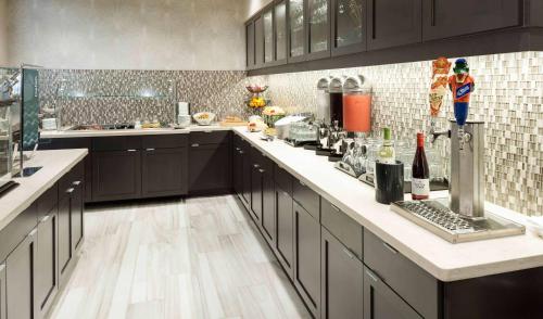 a kitchen with black cabinets and a white counter top at Homewood Suites by Hilton Cape Canaveral-Cocoa Beach in Cape Canaveral
