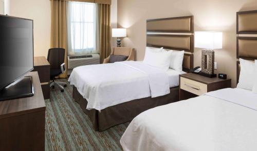 Habitación de hotel con 2 camas y TV de pantalla plana. en Homewood Suites by Hilton Cape Canaveral-Cocoa Beach en Cape Canaveral