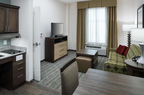 a hotel room with a kitchen and a living room at Homewood Suites by Hilton Cape Canaveral-Cocoa Beach in Cape Canaveral