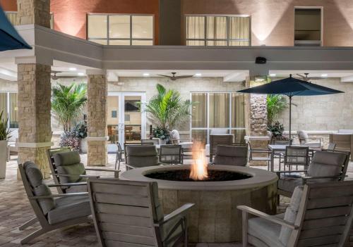 a lobby with a fire pit and tables and chairs at Hampton Inn & Suites Cape Canaveral Cruise Port, Fl in Cape Canaveral