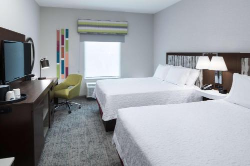 a hotel room with two beds and a flat screen tv at Hampton Inn & Suites Cape Canaveral Cruise Port, Fl in Cape Canaveral