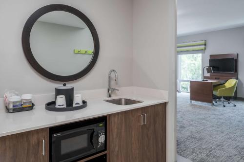 a kitchen with a sink and a mirror at Hampton Inn & Suites Cape Canaveral Cruise Port, Fl in Cape Canaveral