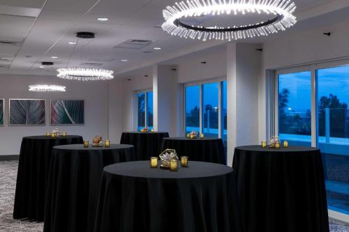 a conference room with black tables and chandeliers at Hampton Inn & Suites Cape Canaveral Cruise Port, Fl in Cape Canaveral