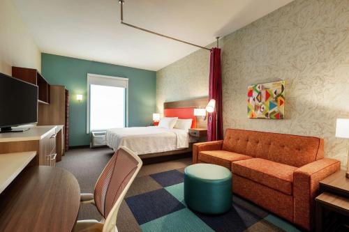 Habitación de hotel con cama y sofá en Home2 Suites By Hilton Statesboro, en Statesboro