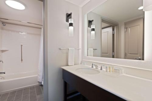 a bathroom with a sink and a large mirror at Homewood Suites by Hilton St Augustine San Sebastian in Saint Augustine