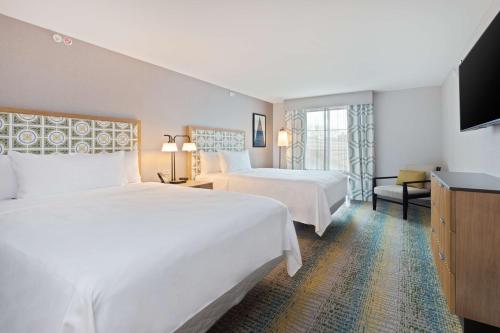 a hotel room with two beds and a television at Homewood Suites by Hilton St Augustine San Sebastian in Saint Augustine