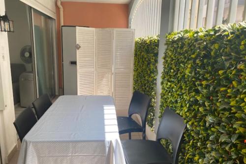 a table and chairs in a room with a green wall at Apartment cosy with terrace 200m from the sandy beaches wifi in Juan-les-Pins