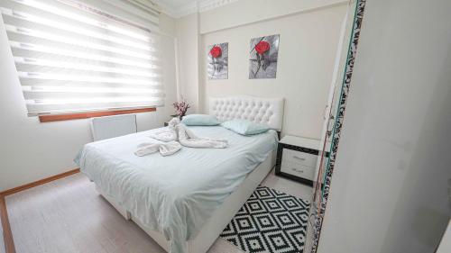 1 dormitorio con 1 cama con toallas en Duman Safir Rezidans, en Kayseri