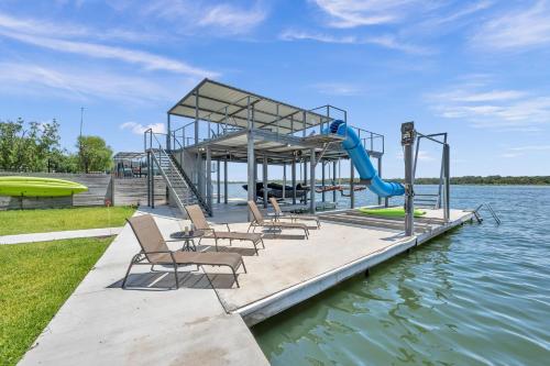a playground on the water with chairs and a slide at Rolling Waves Haven Concierge Services Available in Kingsland