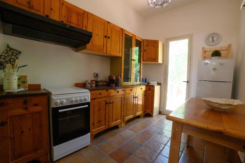 a kitchen with wooden cabinets and a white stove top oven at A L' ARIA FRISCA - villetta a due passi dal mare in Torre Lapillo