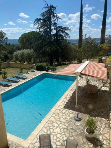 a swimming pool in a yard with chairs and a house at château le perchoir in Montélimar