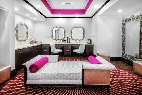 a bedroom with a bed and a vanity with mirrors at Hilton Garden Inn Victoria in Victoria