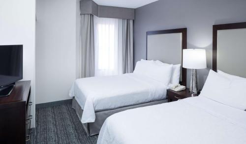 a hotel room with two beds and a flat screen tv at Homewood Suites by Hilton Chattanooga - Hamilton Place in Chattanooga