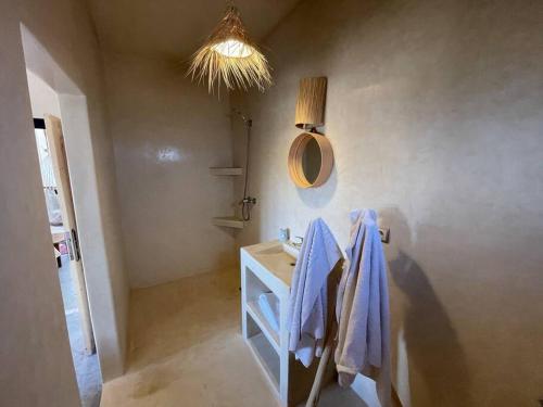 uma casa de banho com um lavatório e um espelho em La Villa Tamazirt, Sidi Kaouki em Essaouira