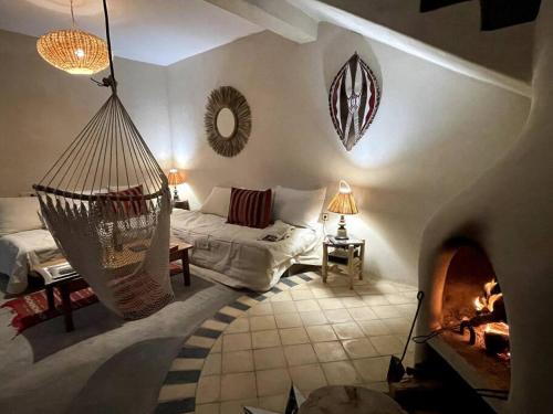 uma sala de estar com uma rede de descanso e uma lareira em La Villa Tamazirt, Sidi Kaouki em Essaouira